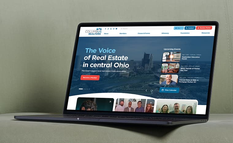 Laptop showing the Columbus REALTORS® homepage - “The Voice of Real Estate in central Ohio” hero with upcoming events